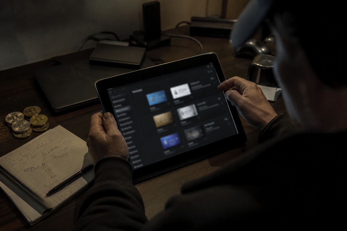 A person analyzing dark web marketplace listings on a tablet, emphasizing the process of buying Visa cards online.